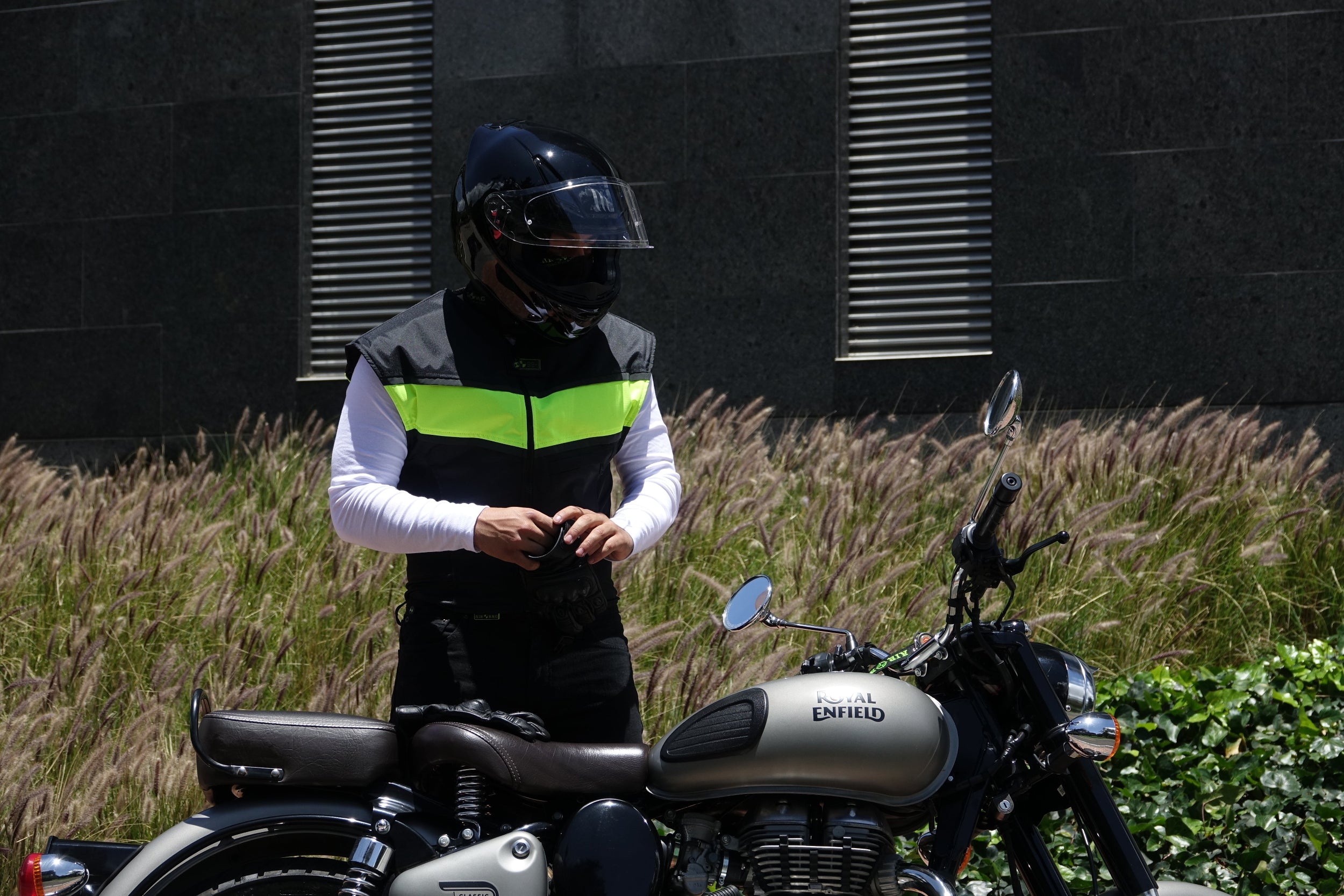 Motorista utilizando el chaleco airbag negro y alta visibilidad WISE VEST de Airobag en un entorno urbano.