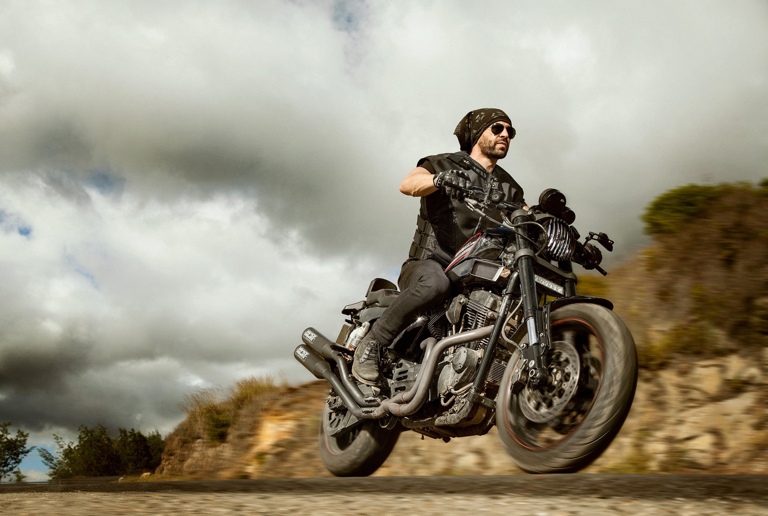 Motorista conduciendo una moto estilo cruiser en carretera protegido con el chaleco airbag de cuero negro CHOPPER VEST.