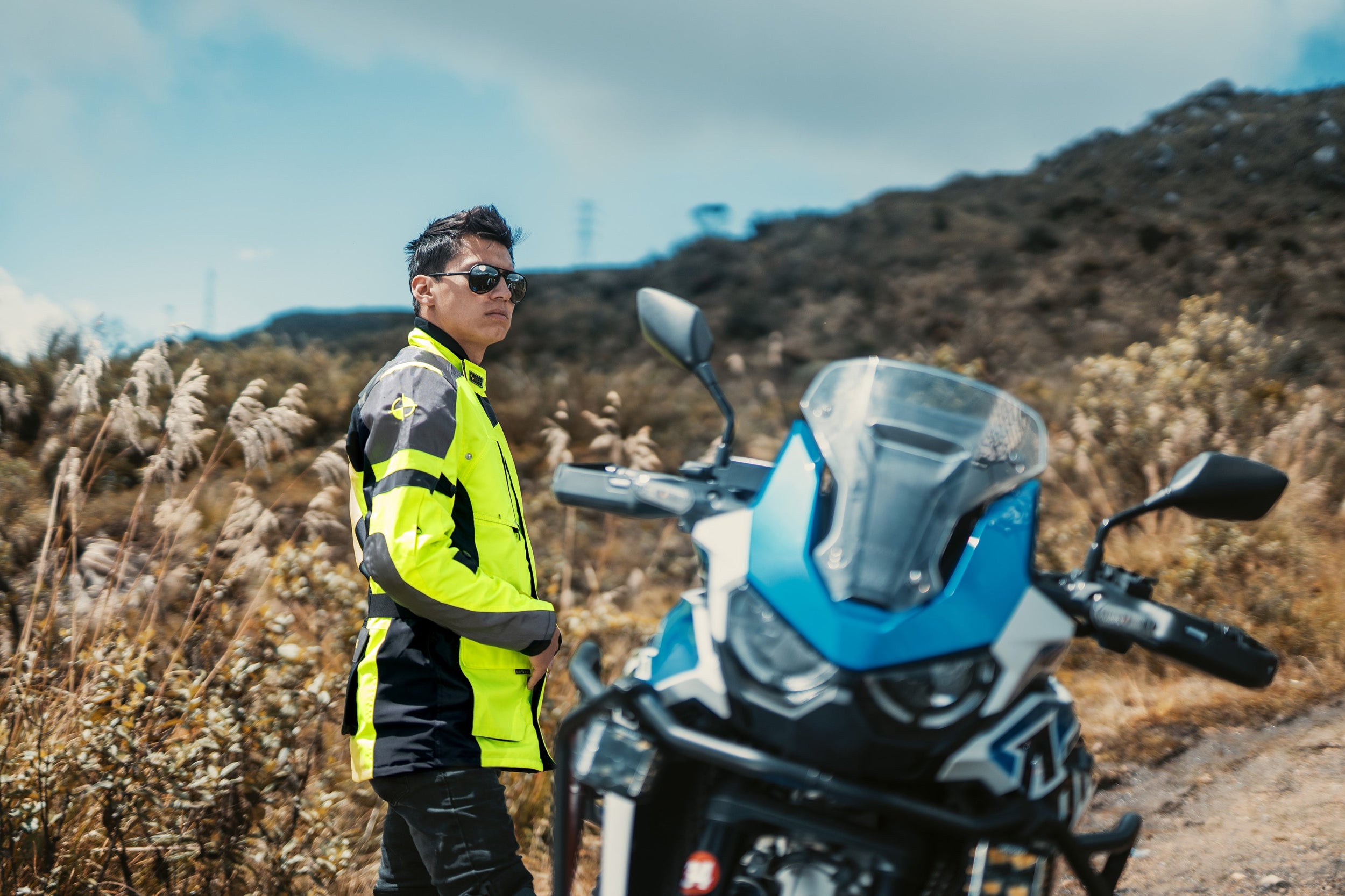 Motorista conduciendo una moto estilo custom protected with the chaleco airbag exterior CHOPPER VEST en color negro