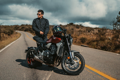Motorista haciendo una parada en su ruta de montaña vistiendo la chaqueta de seguridad URBAN JACKET negra